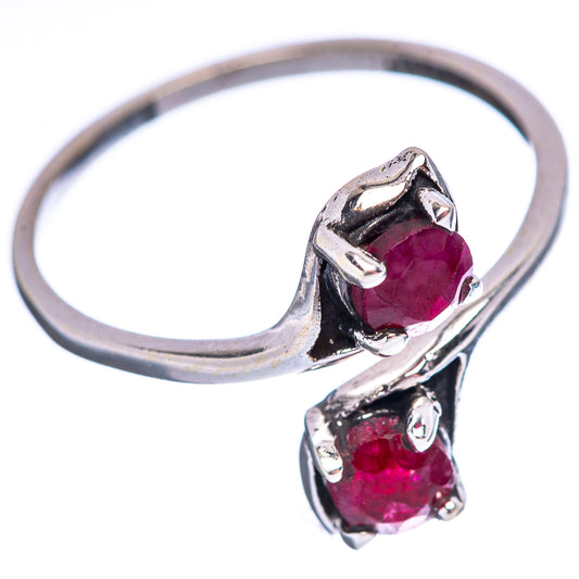 Sterling silver ring with two red faceted gemstones and sculpted prong settings