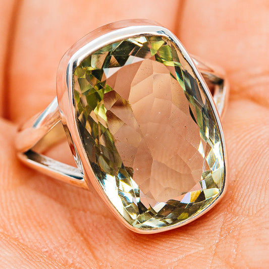 Sterling silver oval amethyst ring with faceted green stone, angled view on hand