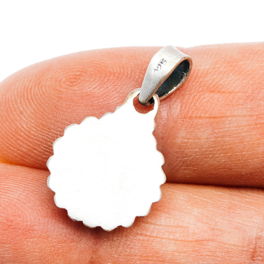 Sterling silver pendant with light-colored cutout back and scalloped edge