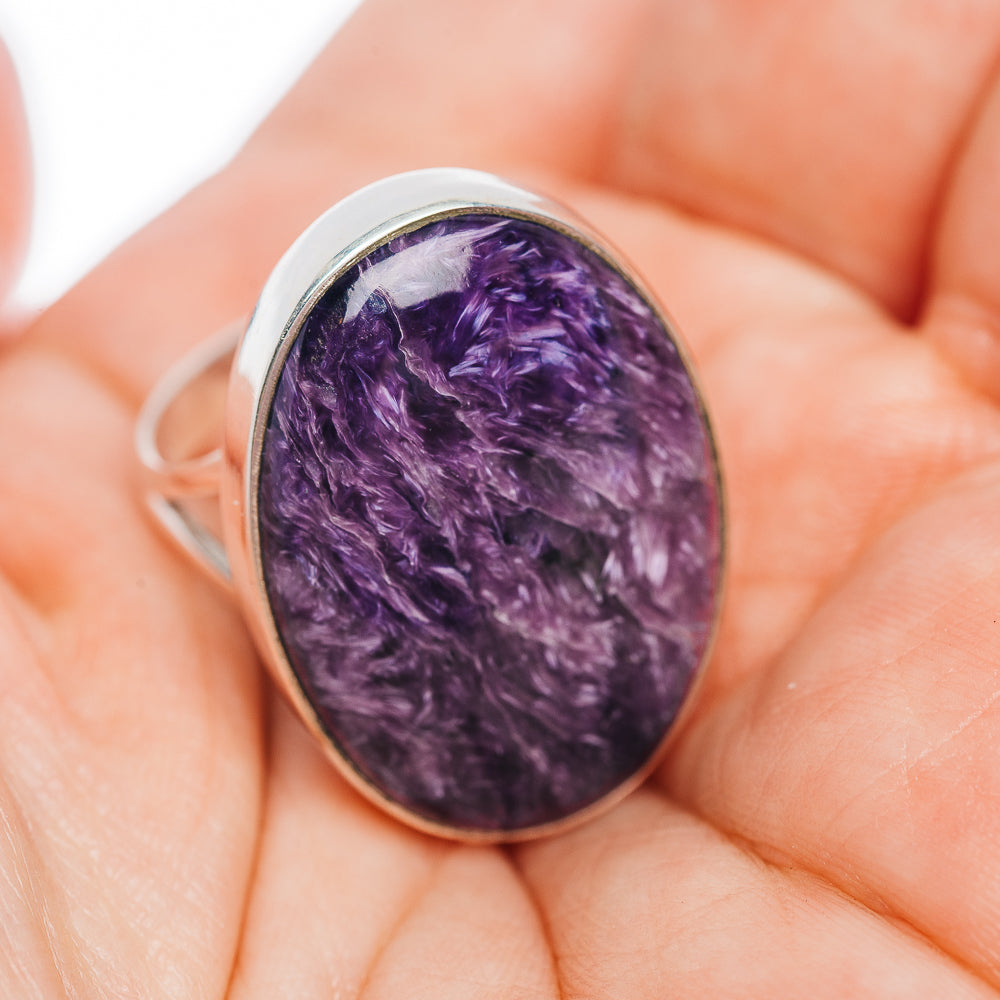 Oval purple charoite cabochon ring on finger, .925 sterling silver, size 9
