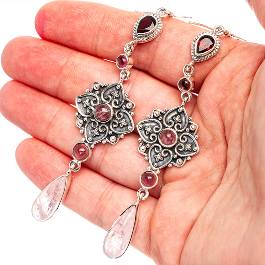 Sterling silver drop earrings with ornate center, pink round stones, and teardrop dangles