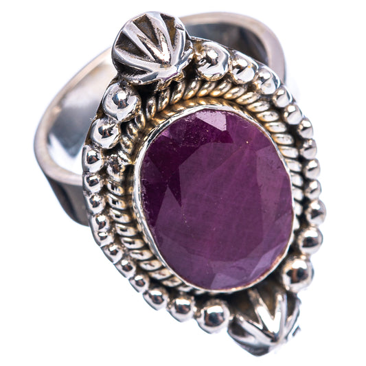 Oval dark red ruby-style ring on silver band with raised bezel and bead edge