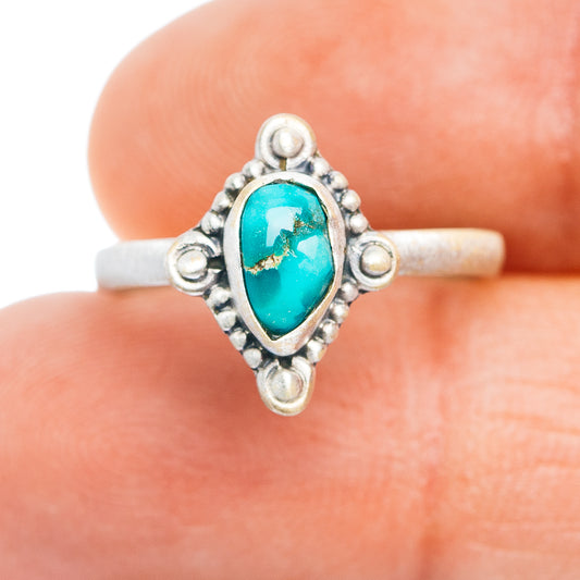 Sterling silver turquoise oval cabochon ring with ornate frame and side accents