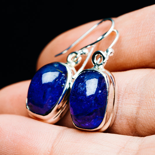 Blue oval tanzanite cabochon earrings with silver drop hooks and bezel settings