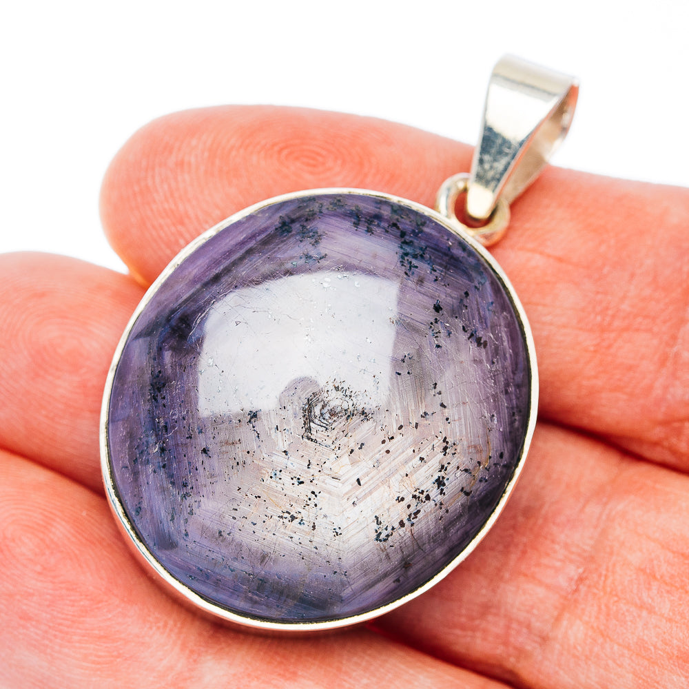 Round sterling silver pendant with dark purple star-like gemstone and top bail