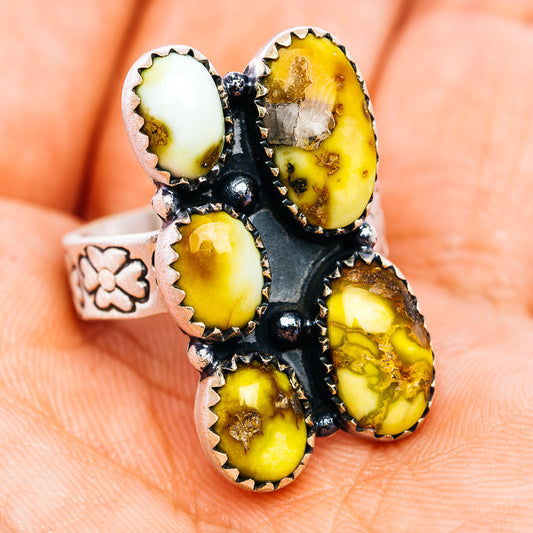 Adjustable sterling silver ring with black prong-set yellow oval stones, flower band detail