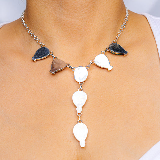 Silver necklace with dark blue teardrop charms and white oval drop pendants
