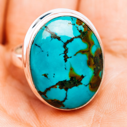 Oval turquoise cabochon sterling silver ring, worn on finger