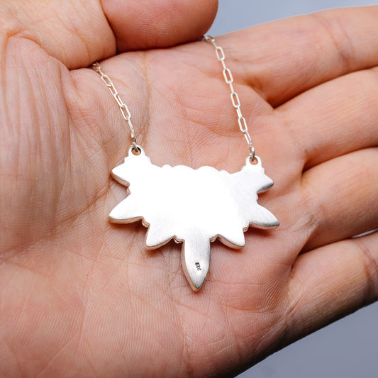 White southwestern sunburst pendant necklace with linked silver chain