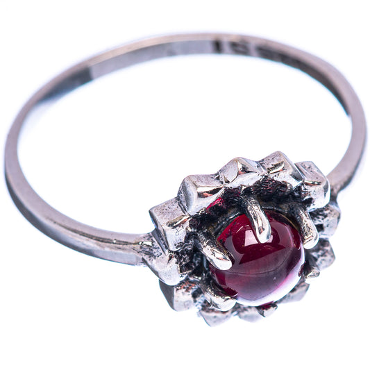 Sterling silver ring with garnet red stone in textured floral setting and slim band