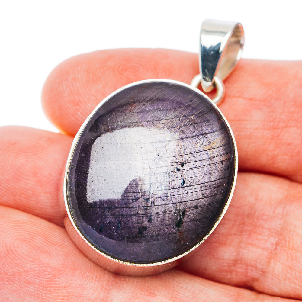 Round sterling silver pendant with dark purple cabochon gemstone, loop bail.