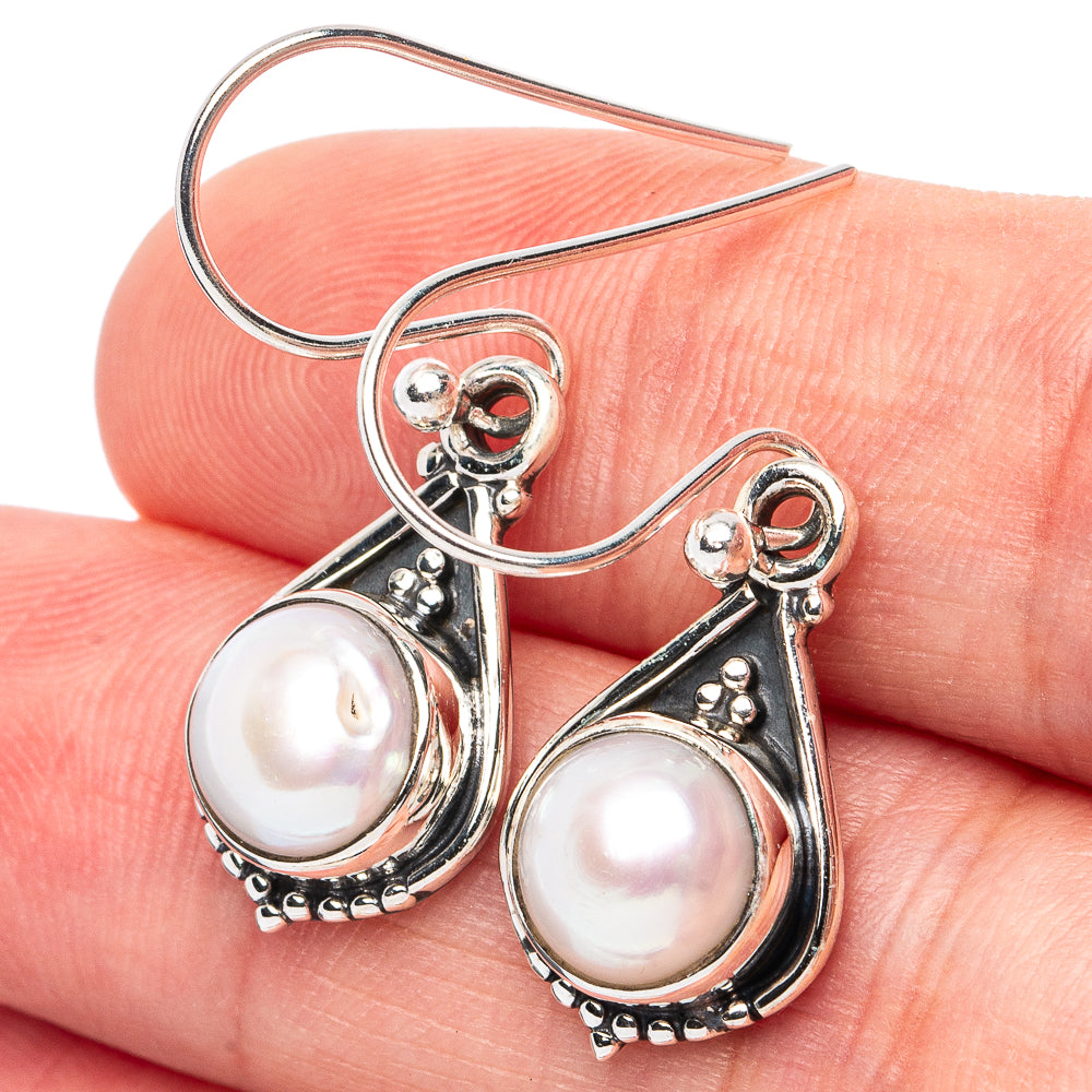Cultured pearl earrings with sterling silver teardrop frames and dangling hooks