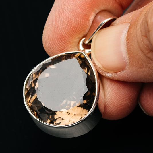 Smoky quartz pear-shaped pendant with faceted stone and .925 sterling silver frame