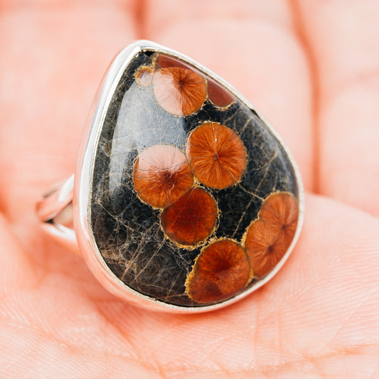 Sterling silver teardrop ring with dark cabochon and scattered orange-red stone spots