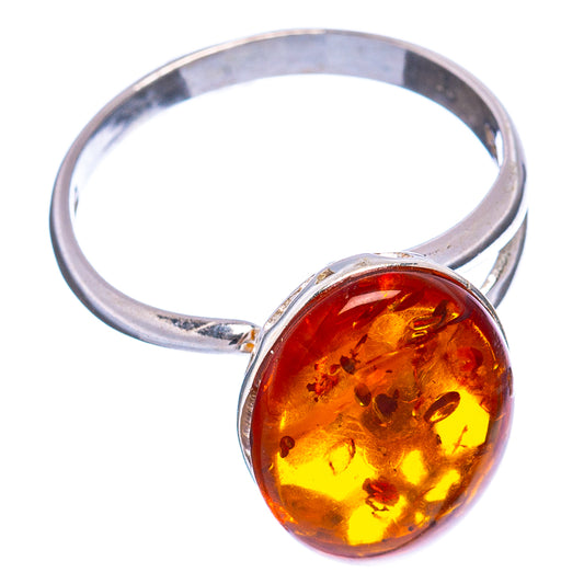 Round yellow-orange amber cabochon on a silver adjustable ring