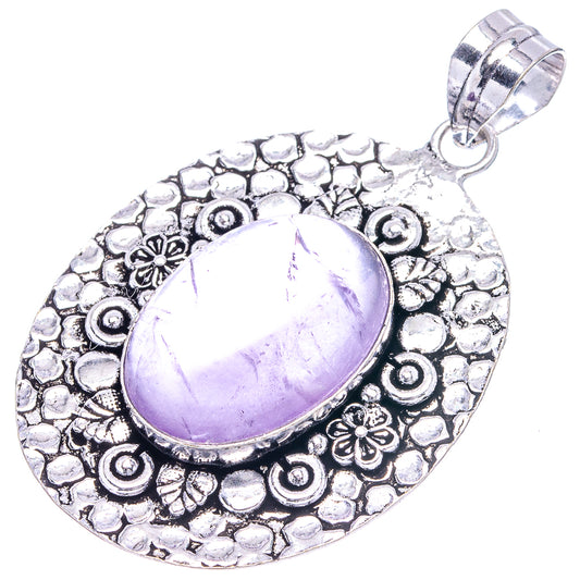 Oval amethyst cabochon pendant with decorative scroll and flower details, bail at top