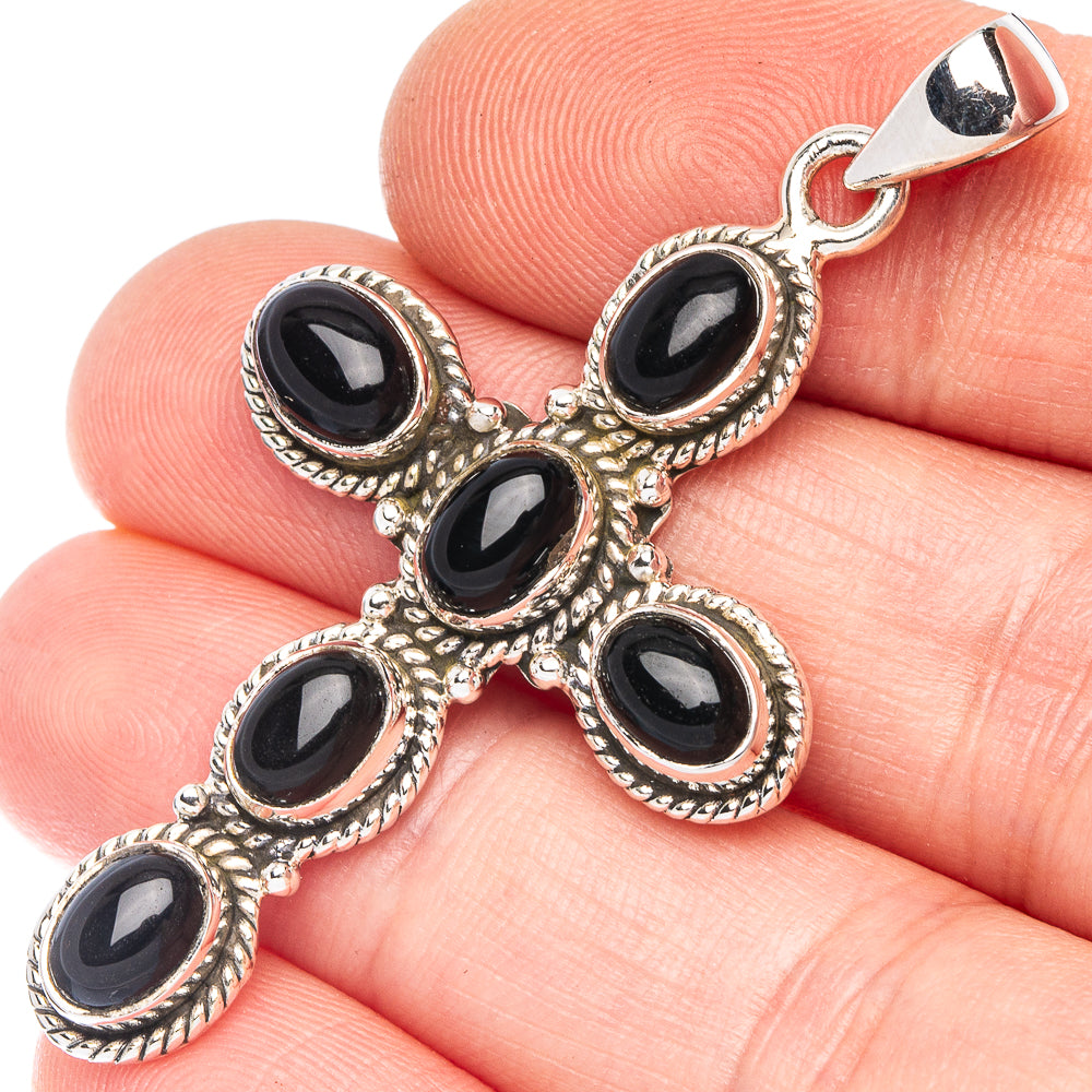 Silver cross pendant with oval black onyx stones and ornate bezel settings