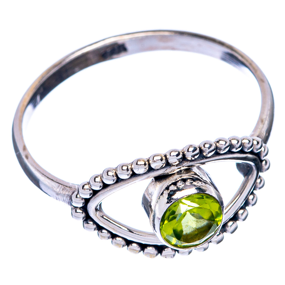 Sterling silver peridot ring with oval green stone, bead bezel, and curved band
