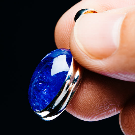 Oval blue gemstone pendant detail with 925 sterling silver bail and high-polish bezel.