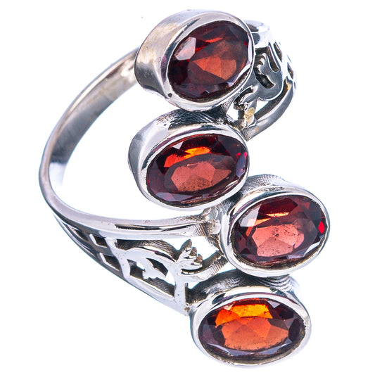 Sterling silver ring with four faceted red garnet stones and openwork band detail.