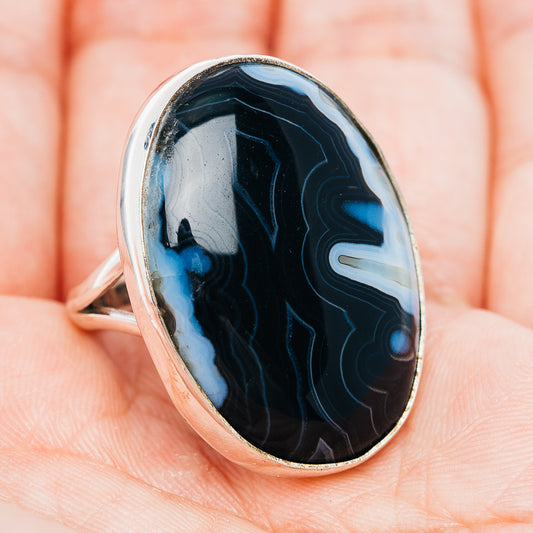 Oval black banded agate ring with sterling silver band, angled side view