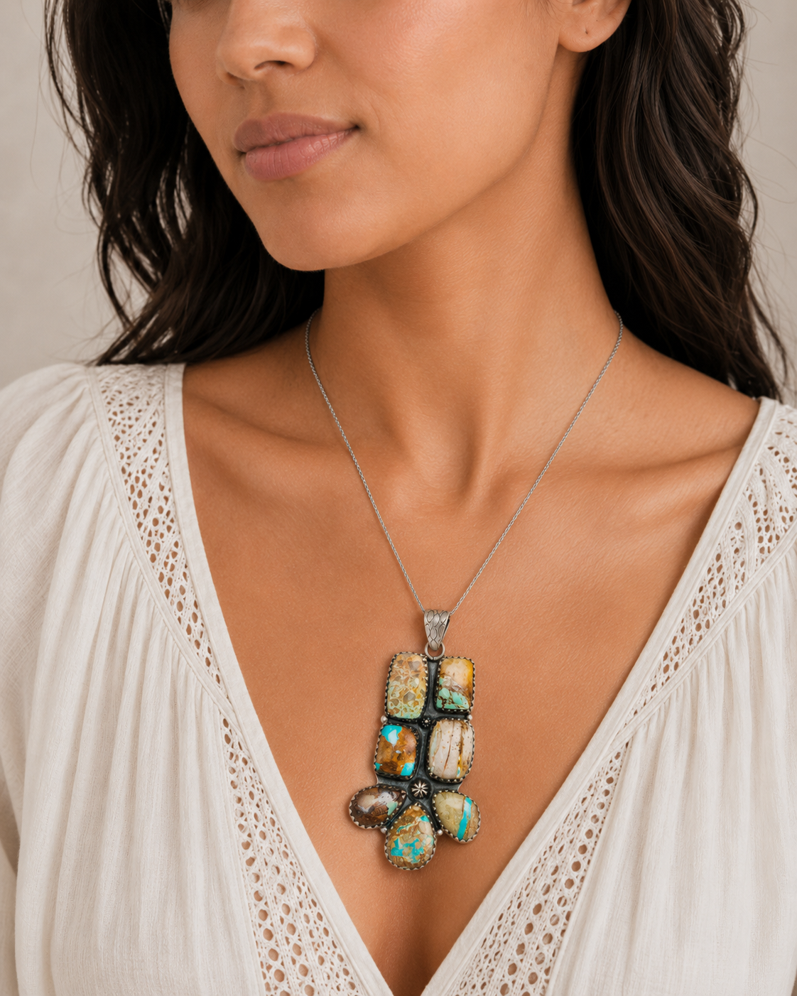 Turquoise mosaic sterling silver pendant on chain, worn on a cream blouse