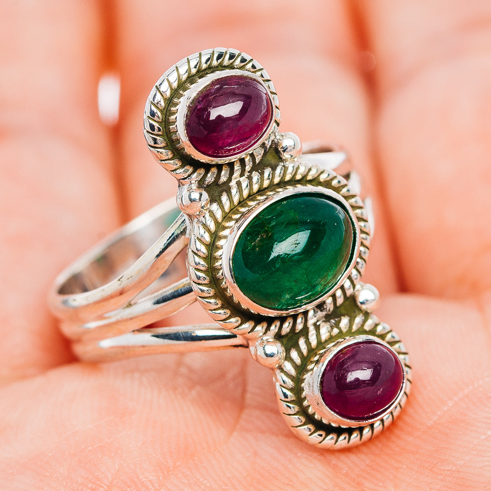 Sterling silver ring with oval green center stone and maroon side gemstones