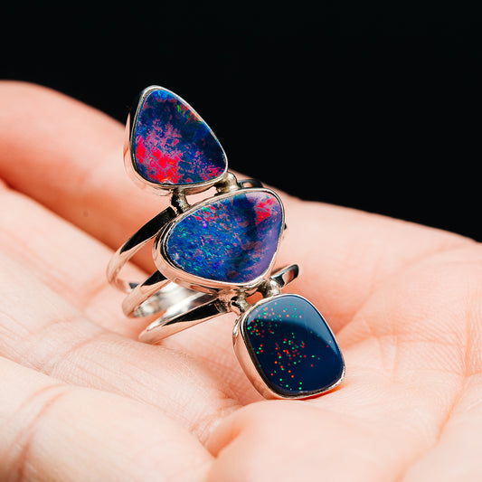 Sterling silver opal doublet ring, three oval blue/red stones with speckled glow detail.
