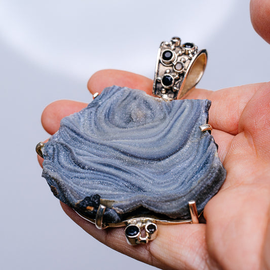 Druzy desert rose pendant top in blue with dark stones and gold-tone accents