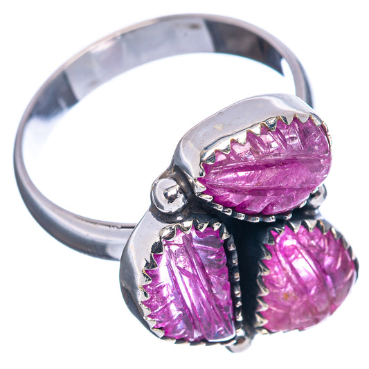 Sterling silver ring side view with three oval magenta ruby stones in dark prongs