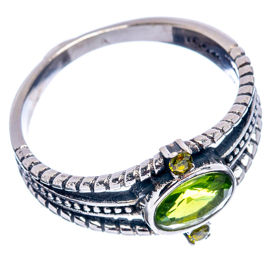 Sterling silver ring band with oval green peridot center stone and small side accents