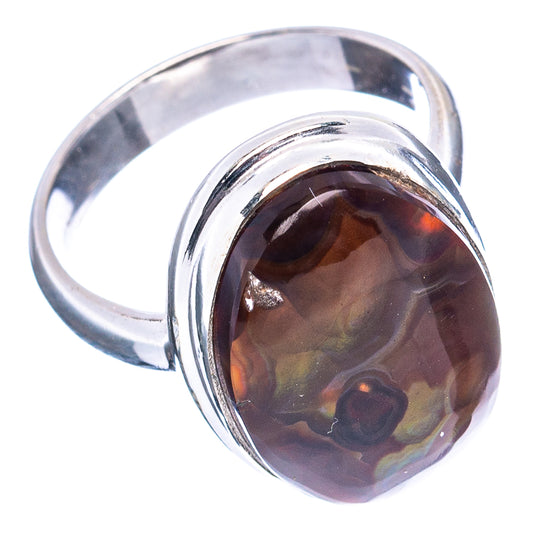 Sterling silver ring showing band and round dark fire agate cabochon with warm amber glow