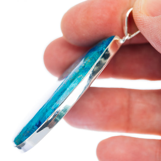 Blue shattuckite pendant with silver edge detail and bail, side view