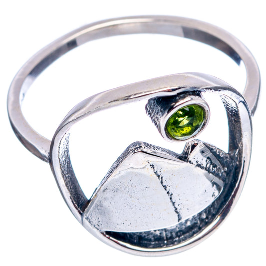 Sterling silver peridot ring featuring green stone bezel and engraved mountain band