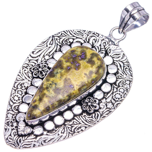 Oval German silver pendant with detailed border, yellow teardrop stone with purple flecks.