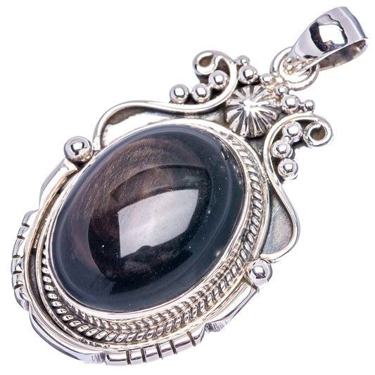Sterling silver pendant with oval dark cabochon stone, decorative scrollwork and sparkle accents