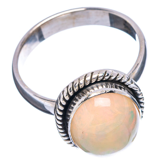 Sterling silver opal ring with round pale opal cabochon and carved bezel on textured band