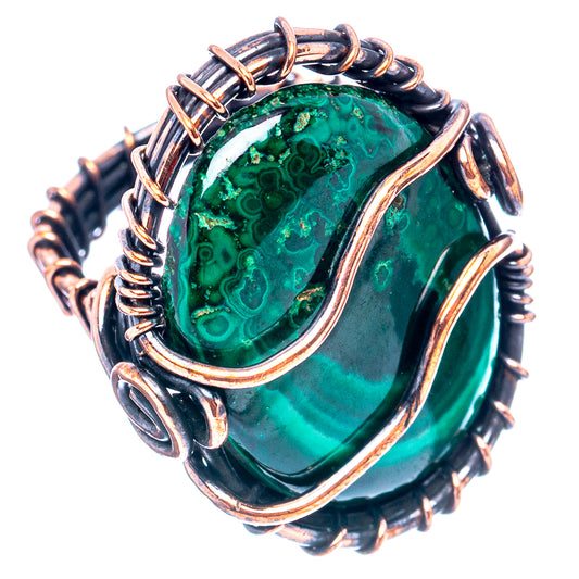 Oxidized copper wire wrap ring with oval green malachite stone, close-up.