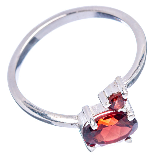 Sterling silver ring with raised dark red garnet center and three prong-set red stones