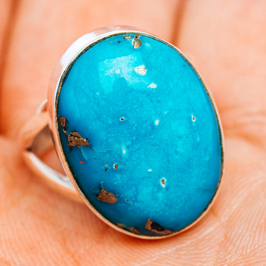 Turquoise oval gemstone ring with .925 sterling silver band, angled view