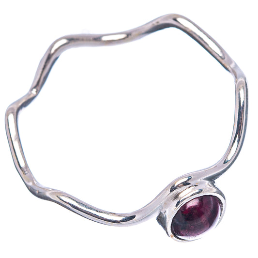 Dainty garnet ring with wavy open silver band and oval dark red gemstone cabochon.