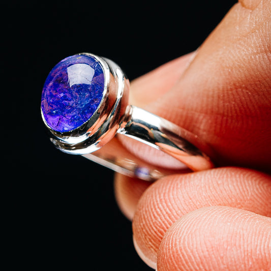 Bezel-set oval blue-violet gemstone sterling silver ring, side angle on finger