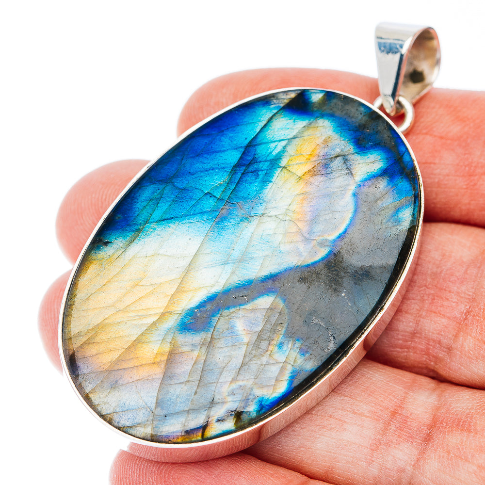 Oval sterling silver pendant with iridescent blue and gold stone, hinged bail