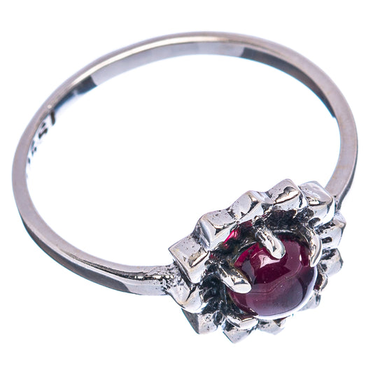 Sterling silver band ring with dark red oval center stone and claw prongs