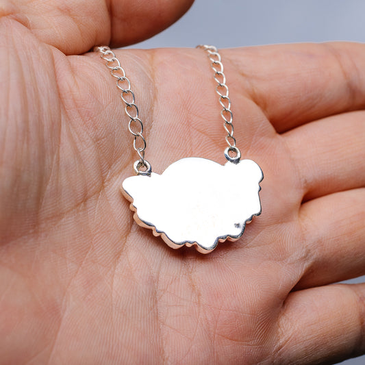 Silver-tone chain necklace with round scalloped pendant close-up