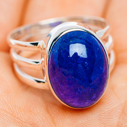 Sterling silver ring with oval blue-purple cabochon gemstone and open shoulders.