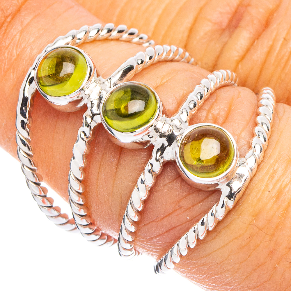 Silver ring with three round peridot-green gemstones and twisted rope edges