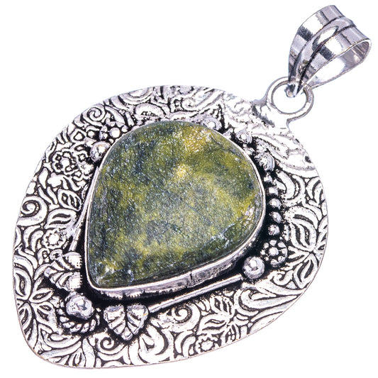 German silver teardrop pendant showing yellow-green stone, ornate border, and loop bail