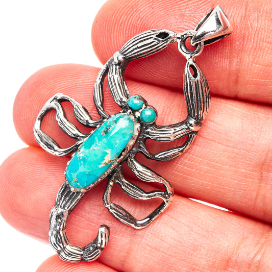 Silver earrings with turquoise cabochon and small bead accents on ornate setting