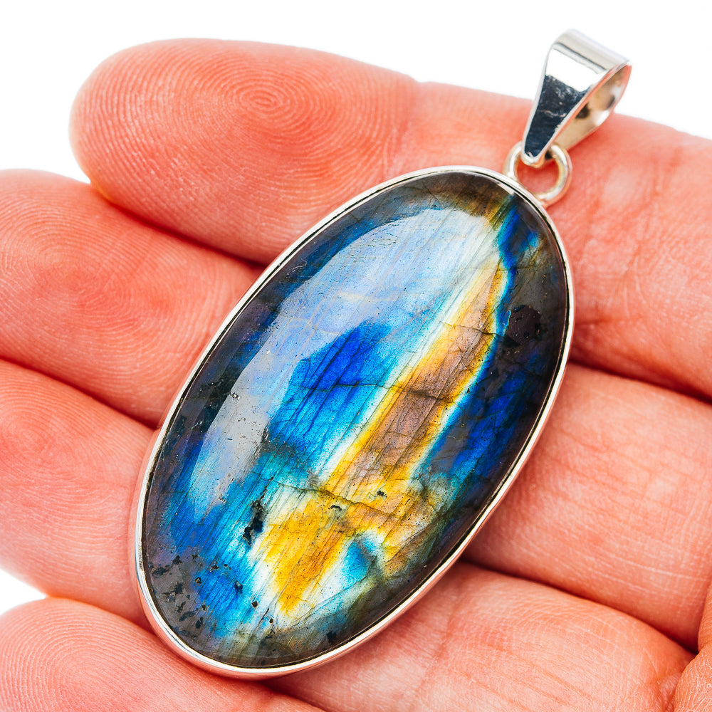 Oval sterling silver spectrolite pendant with iridescent blue and gold stone
